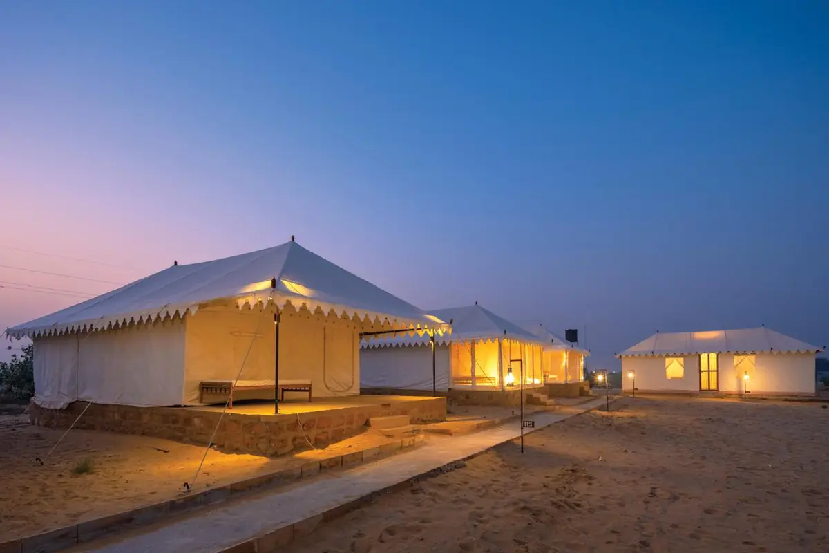 Swiss tents lit at dusk at the Sam desert camp
